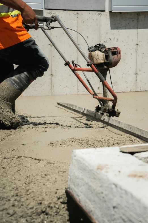 a man is pouring cement into a sidewalk