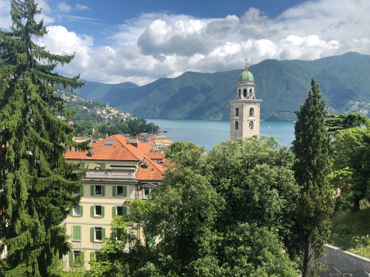 a very tall tower in the middle of trees with a lake in the background