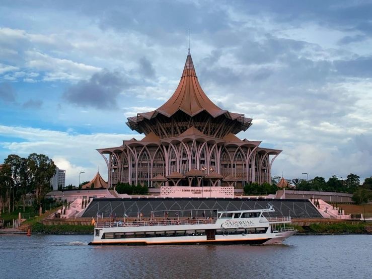 a boat is in front of an ornate building on the water