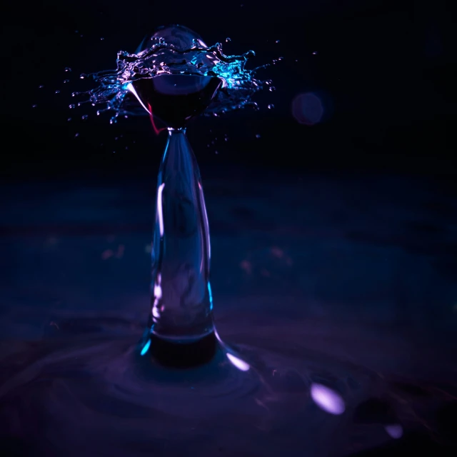 a glass object in the dark with water on it