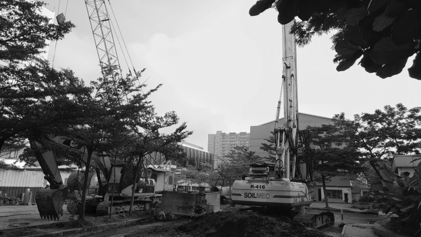 a crane sitting over a tree in a city