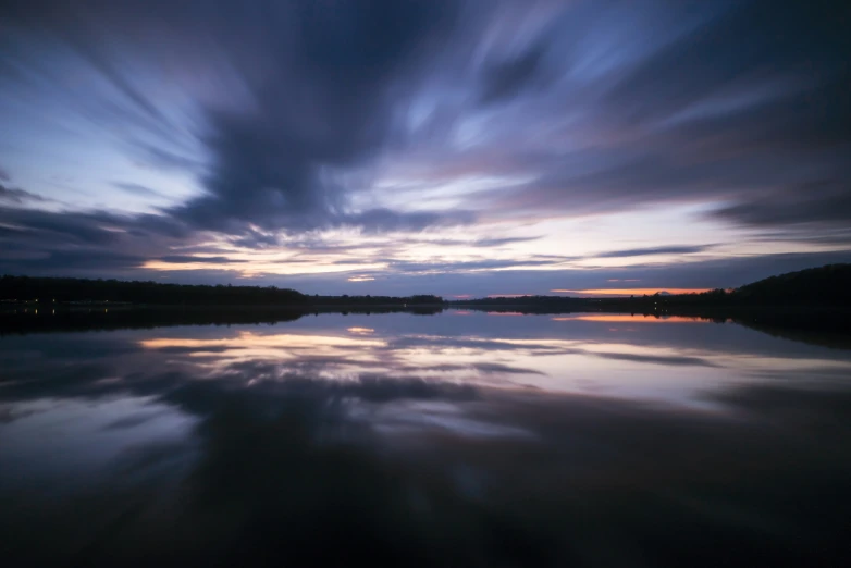 a view of an intense sky reflected on the still water