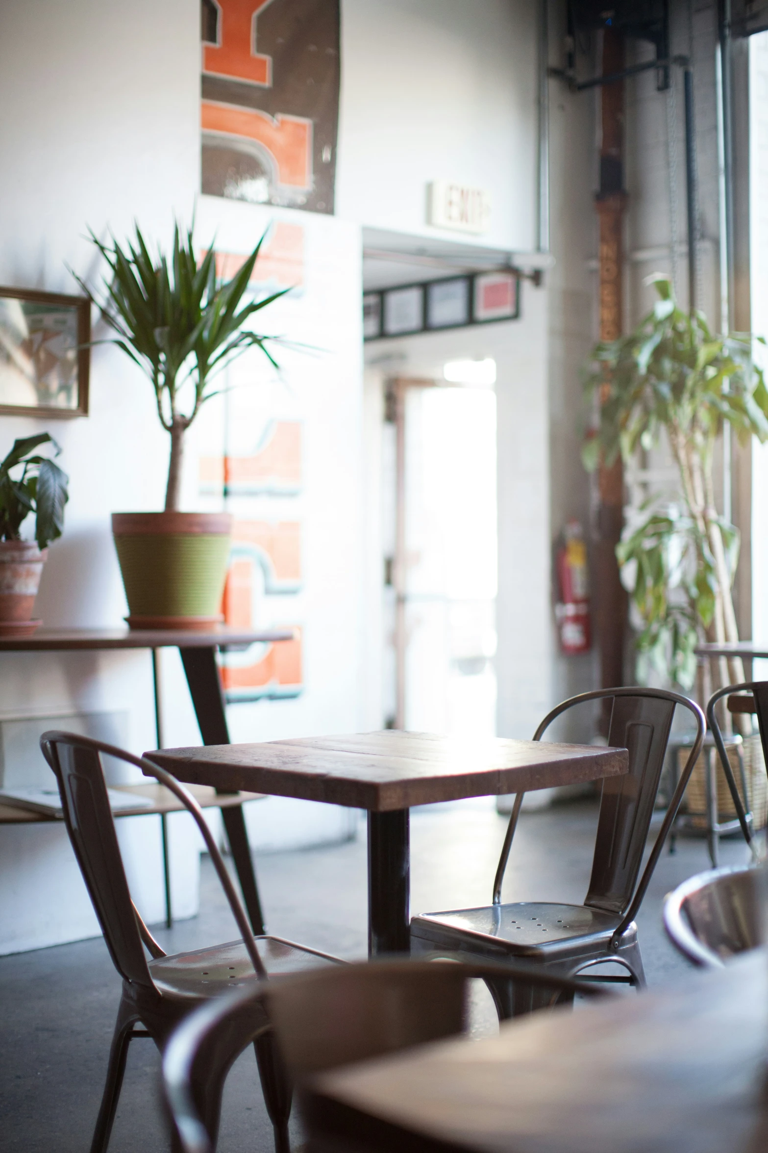 several wooden tables sitting in a room with two windows