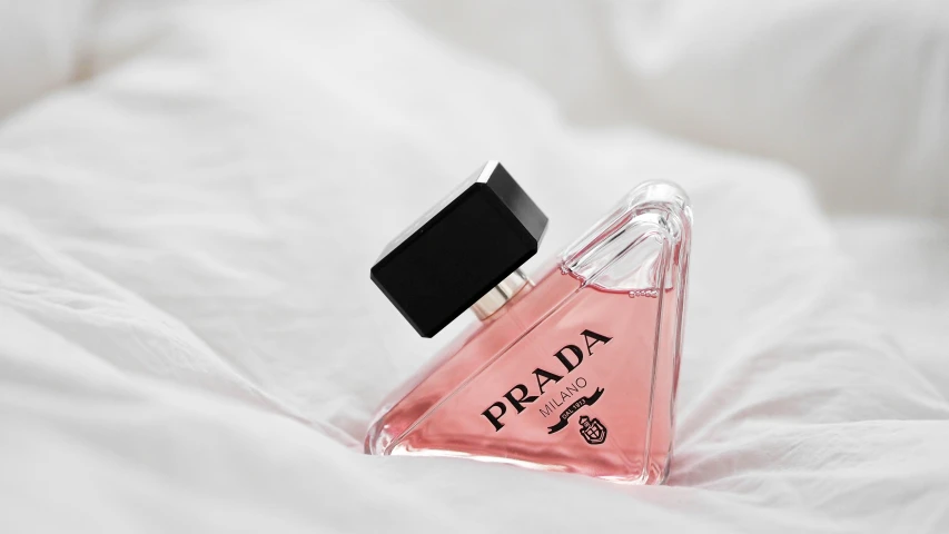 a bottle of perfume on top of a bed