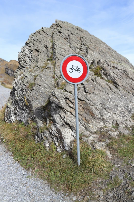 an odd road sign on the side of a large rock