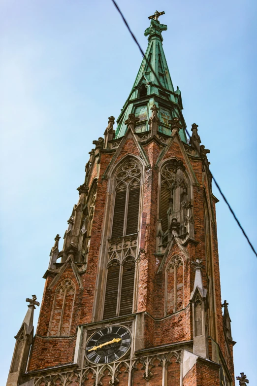 an ornate building has a clock and a green steeple