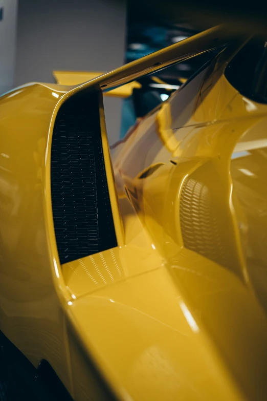 a close up of a yellow sports car with black markings