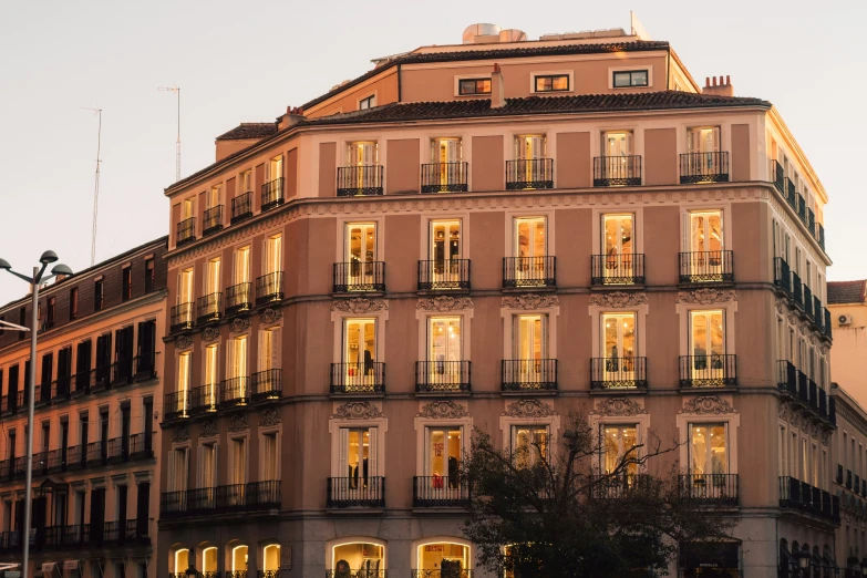 the side of a building with windows lit up at dusk