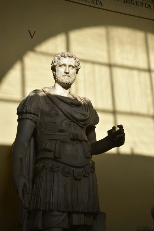 a statue of a man standing next to a wall