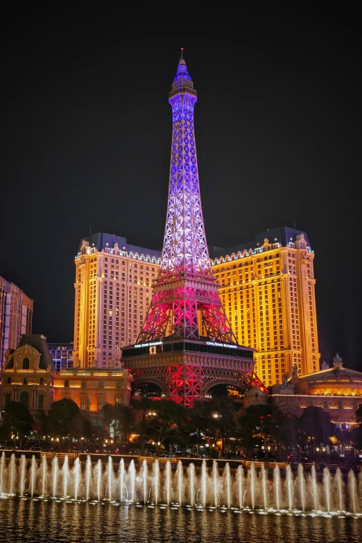 eiffel tower is lit up in front of the paris las vegas el and casino