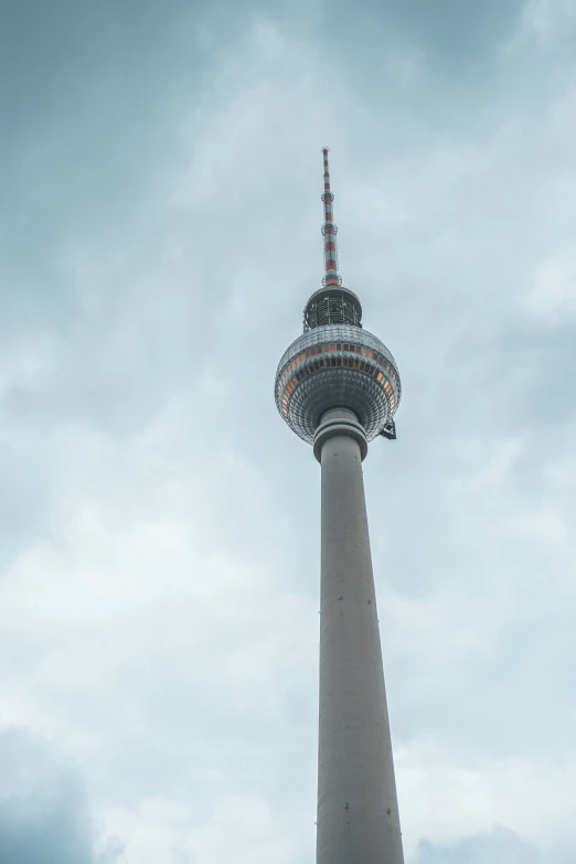 a tall tower is surrounded by clouds and blue sky