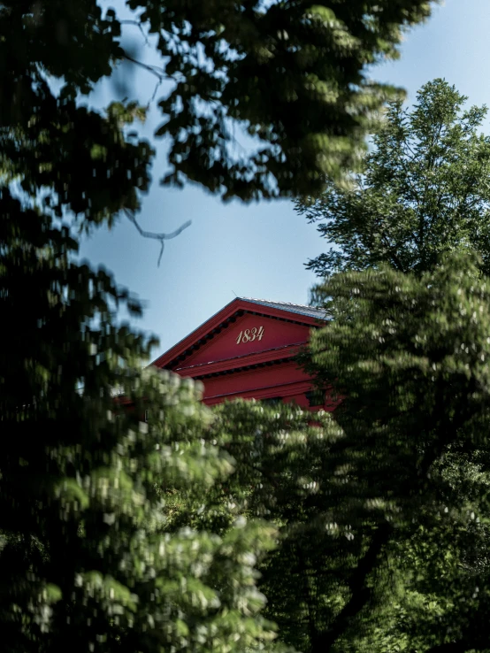 the large red building on top of a building with trees around