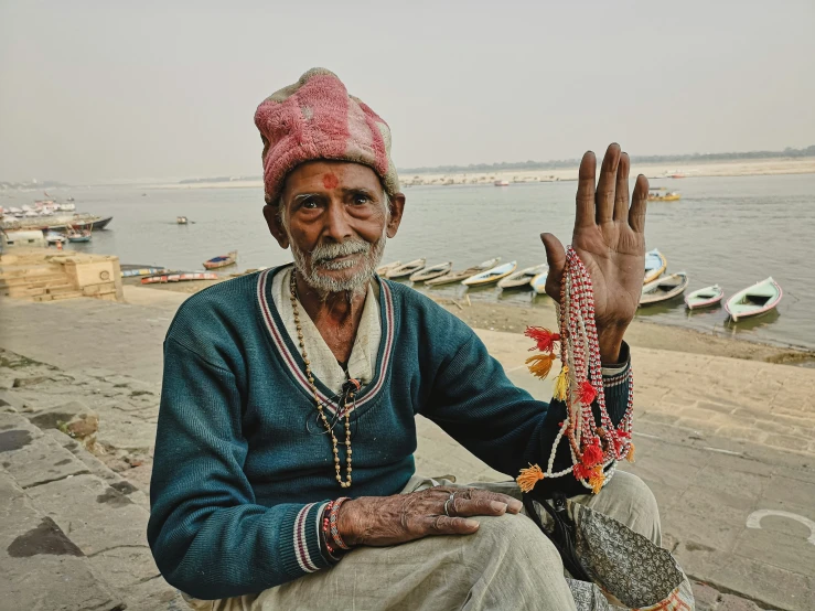 a man with painted face sitting next to water