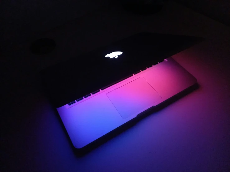 a laptop with colored light up is sitting on the desk