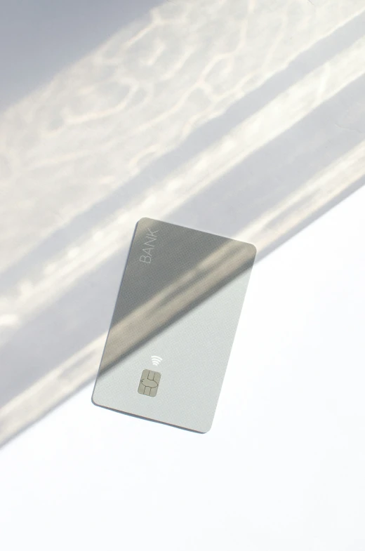 a white credit card with a shadow on it