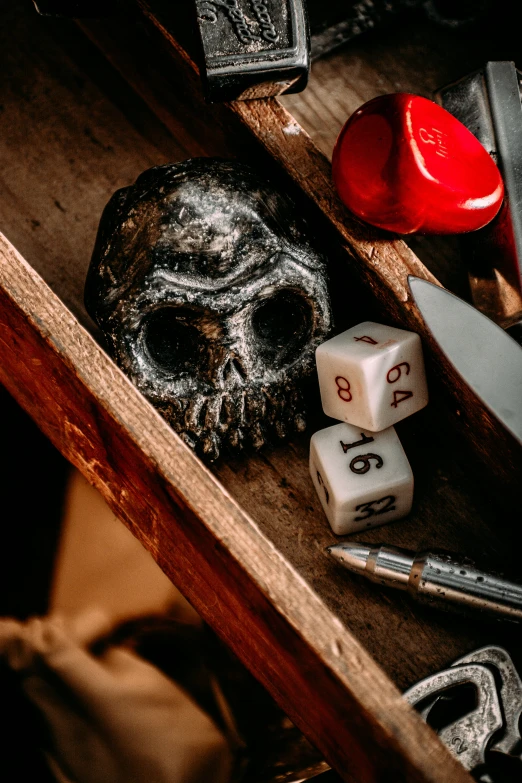 dices, skulls and red hearts are laying on a wooden table