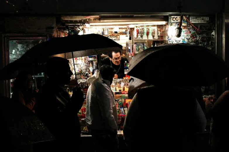 a group of people standing under umbrellas in the dark