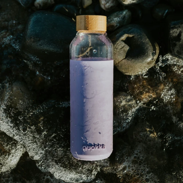 a bottle that is sitting on some rocks