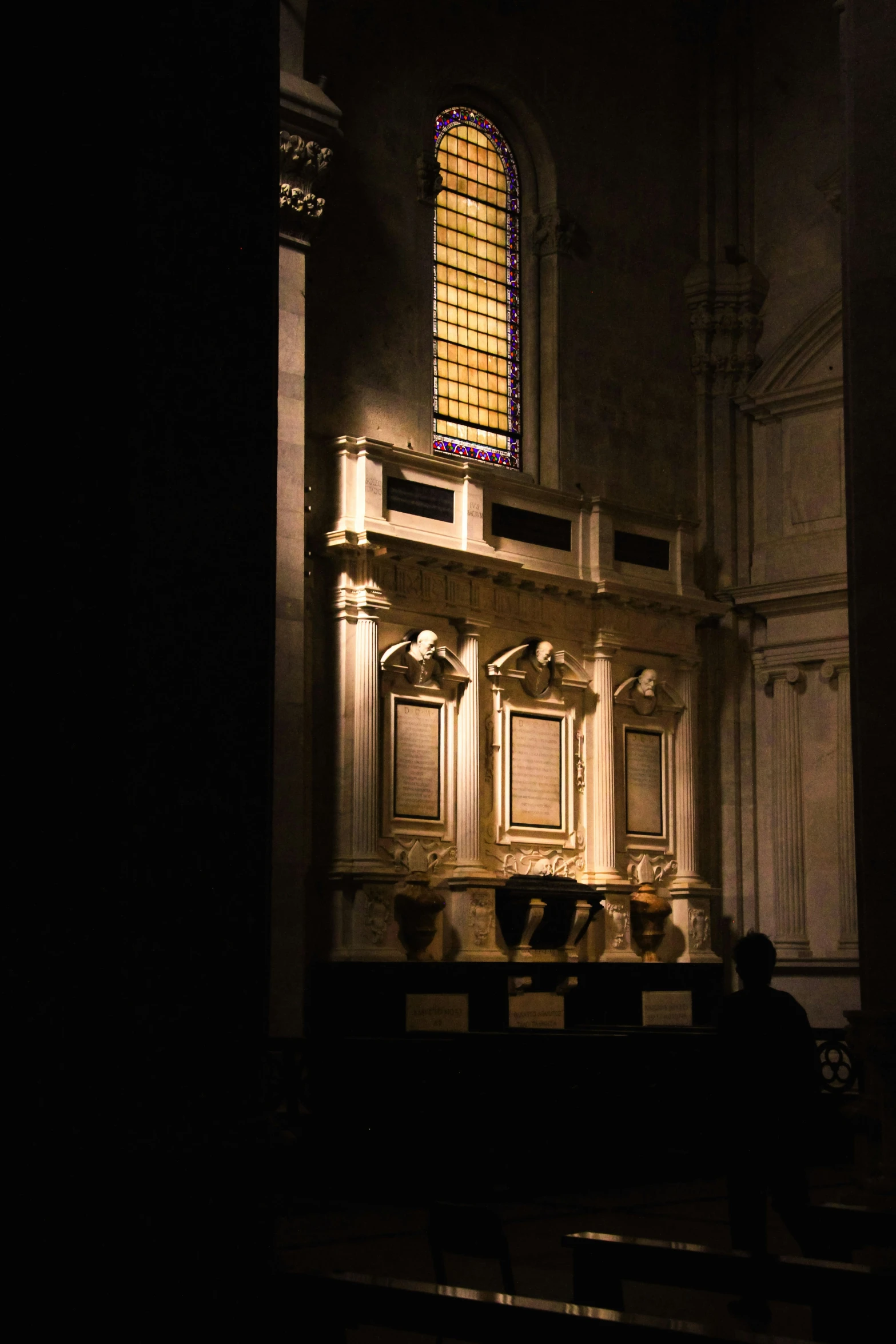 a dimly lit alter in a church with benches