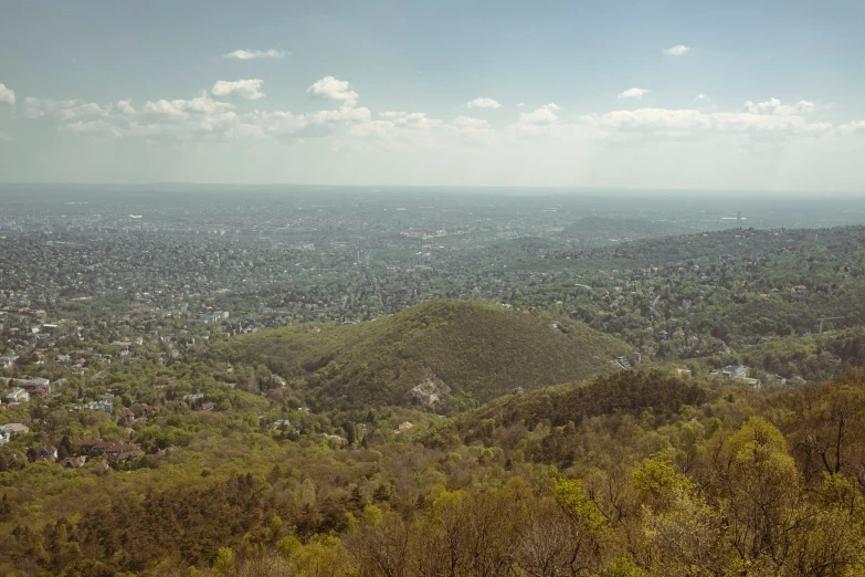 a hilly green field and valley below in the day