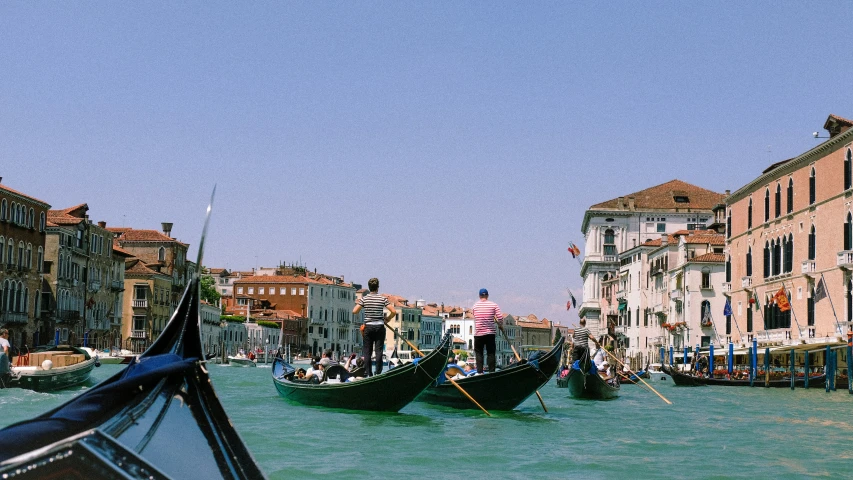 a group of people riding boats on a narrow canal