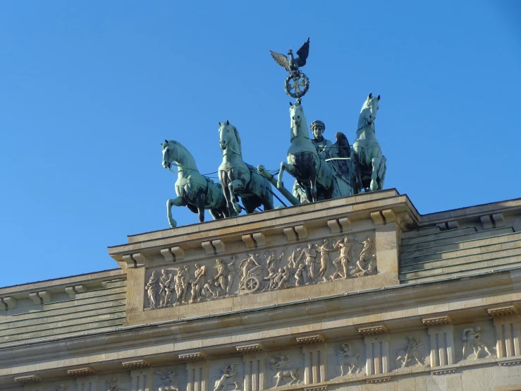 the top of an architectural structure with two statues on horses