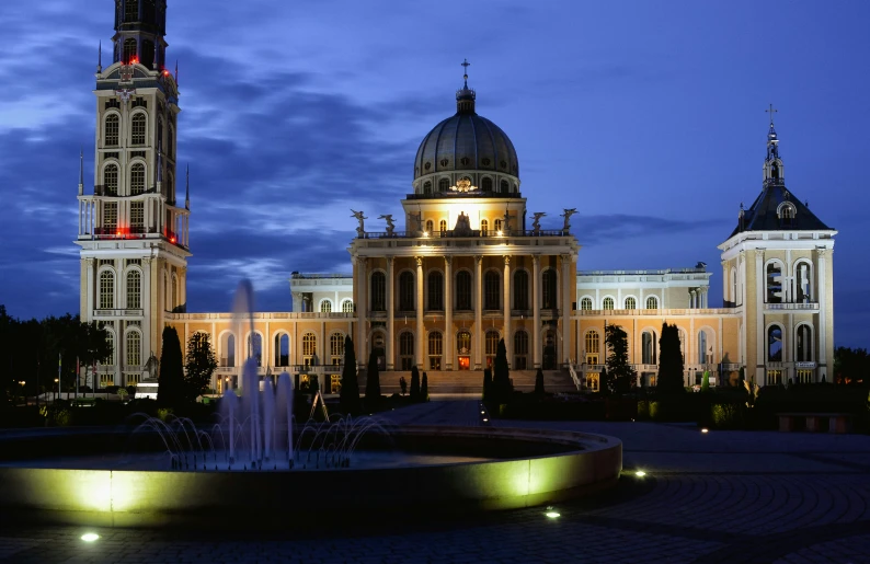 the building has a clock and water feature in front