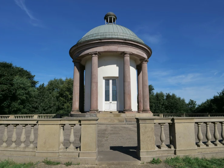 a circular tower with a dome is sitting on a cement fence