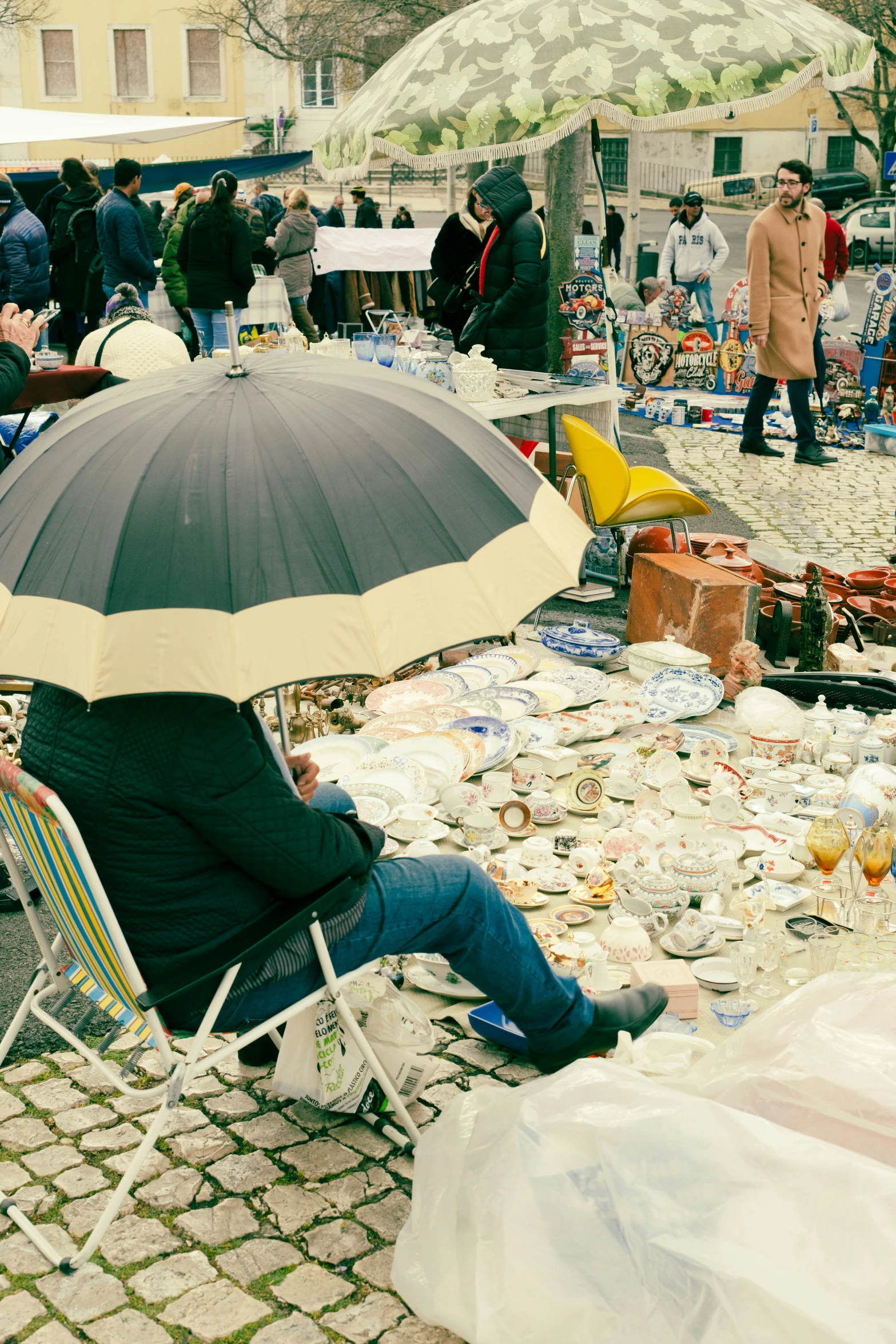 a person sitting in a chair with an umbrella