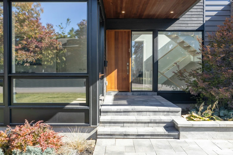 an entryway is flanked by large, clear windows