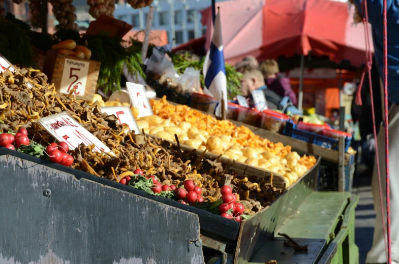 a fruit stand in the city market with several types of foods on display