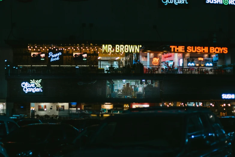 the outside of a restaurant with neon lights on