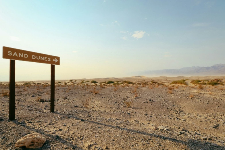 a road sign in a desert area near mountains