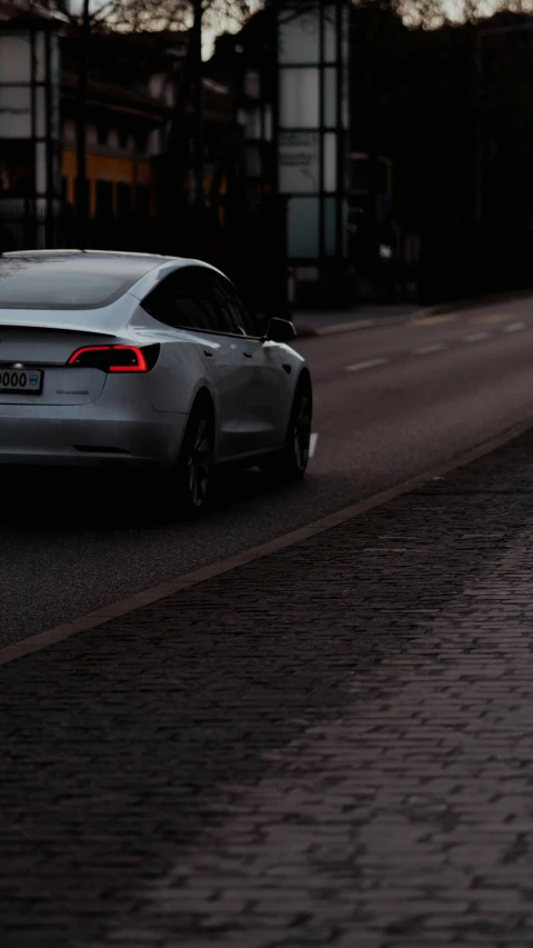 a car is driving down the street at night