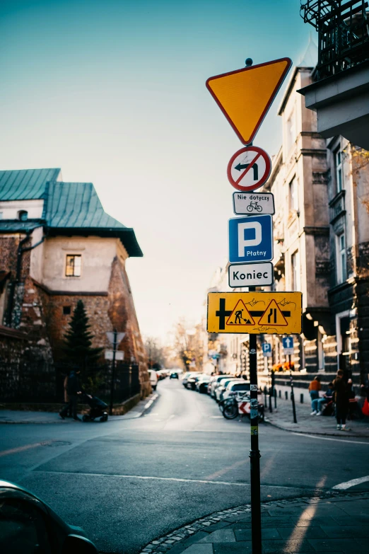 a street with buildings, signs, cars and people walking