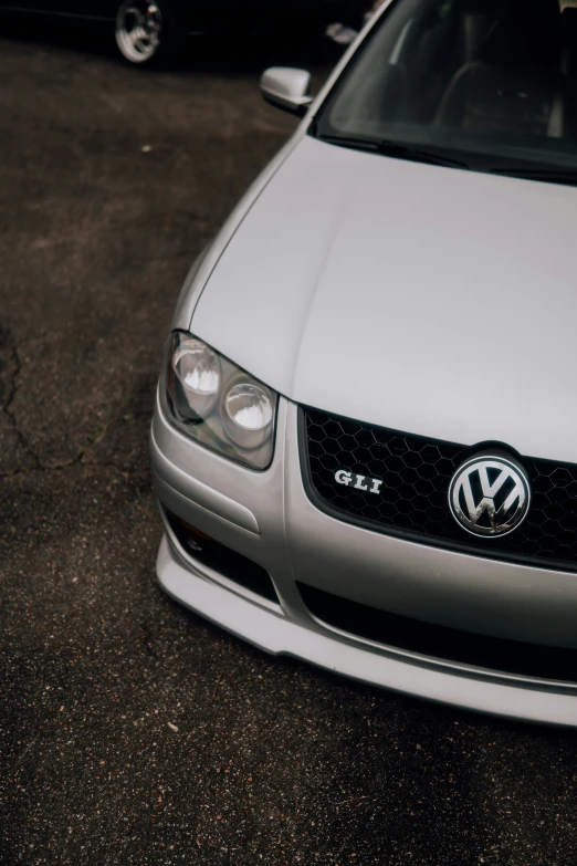 the front end of a car on a dirty parking lot