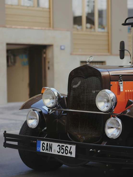 an old antique model car parked near a building