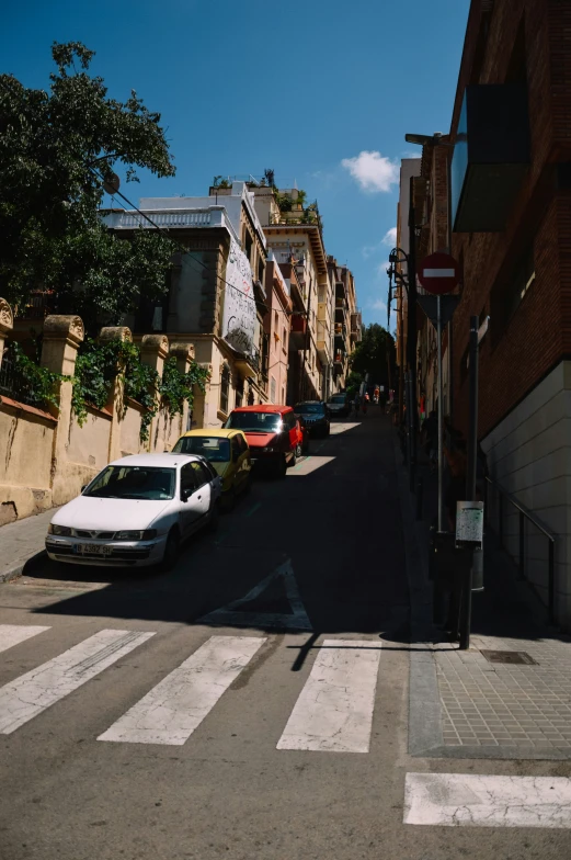 a row of cars are parked in a narrow street