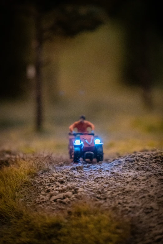 the motorcyclists are driving along through a dark trail