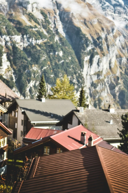 a clock tower with mountains and houses in the background