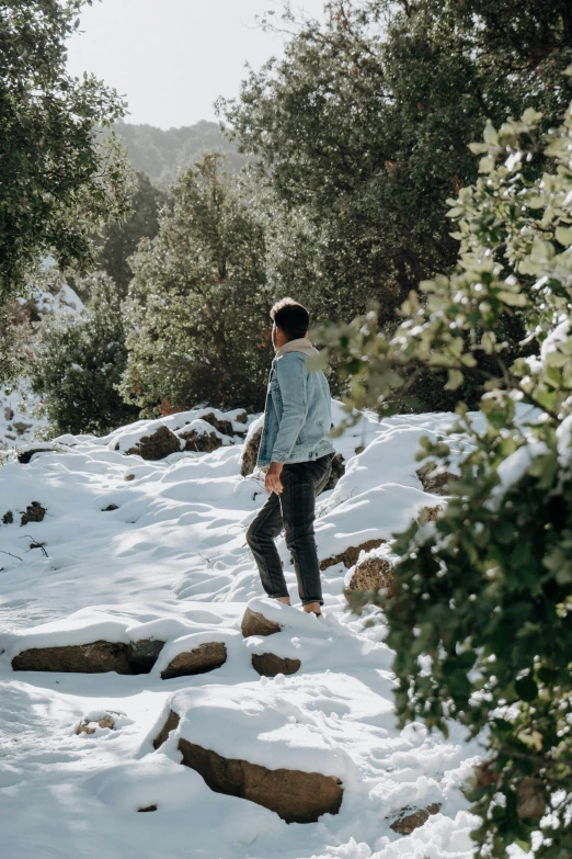 a woman walking up some rocks in the snow