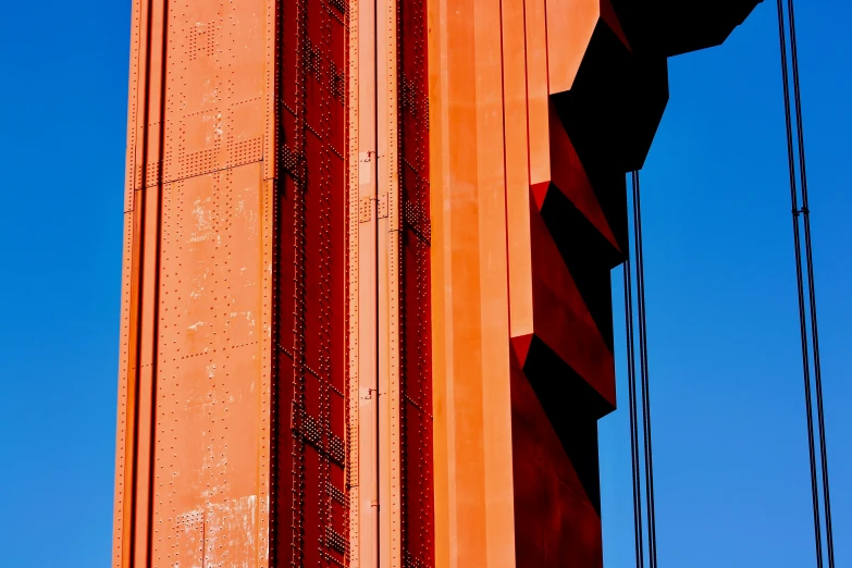 the side of a large orange building with several lines around it