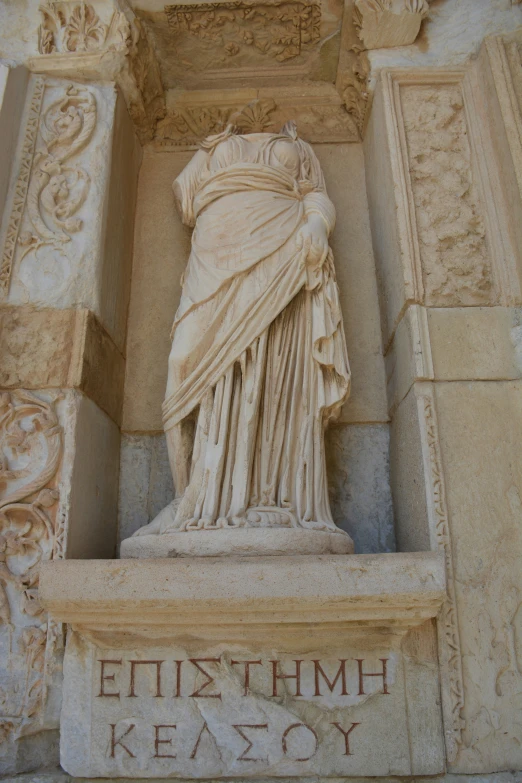 the ancient sculpture is located behind a carving of a woman