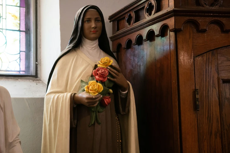 the statue of st mary is holding roses in her hands