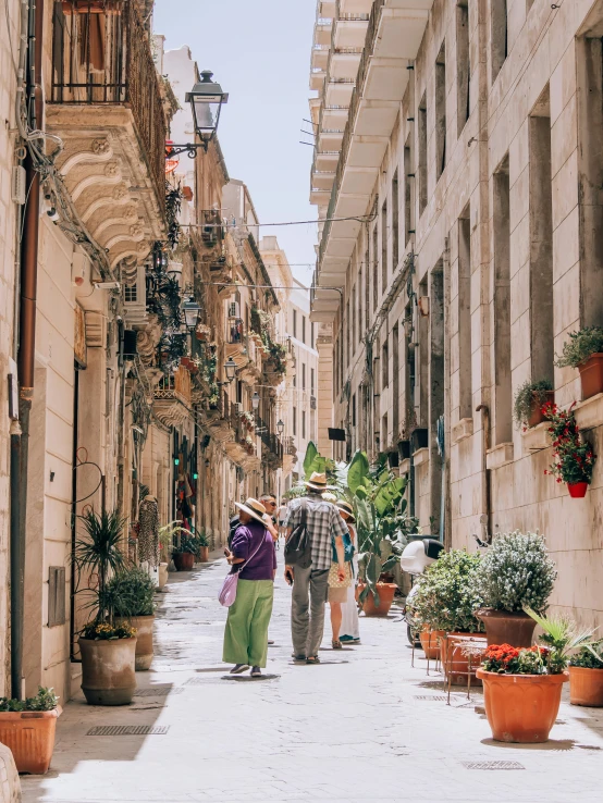 people walking in a narrow stone street in an old part of europe