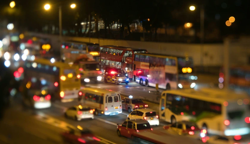 cars and buses wait at night in the city