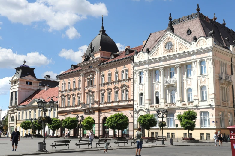 people walking and sitting in the courtyard of an old building