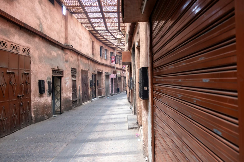 a alley with brown doors next to a building