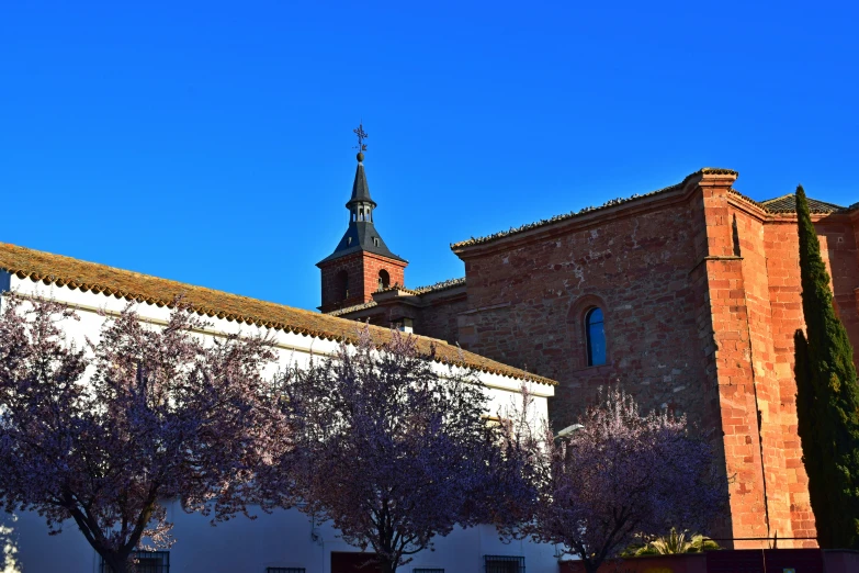 a small building with a tower next to some trees