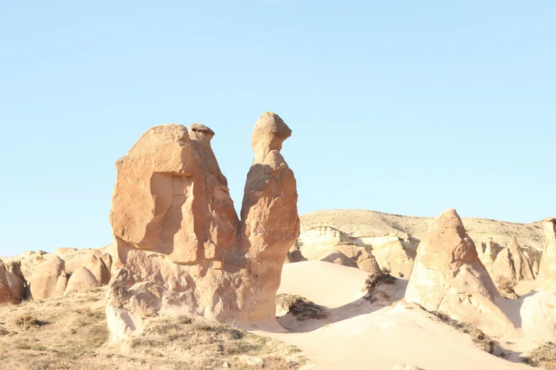 two large rocks sitting on top of a dry grass field